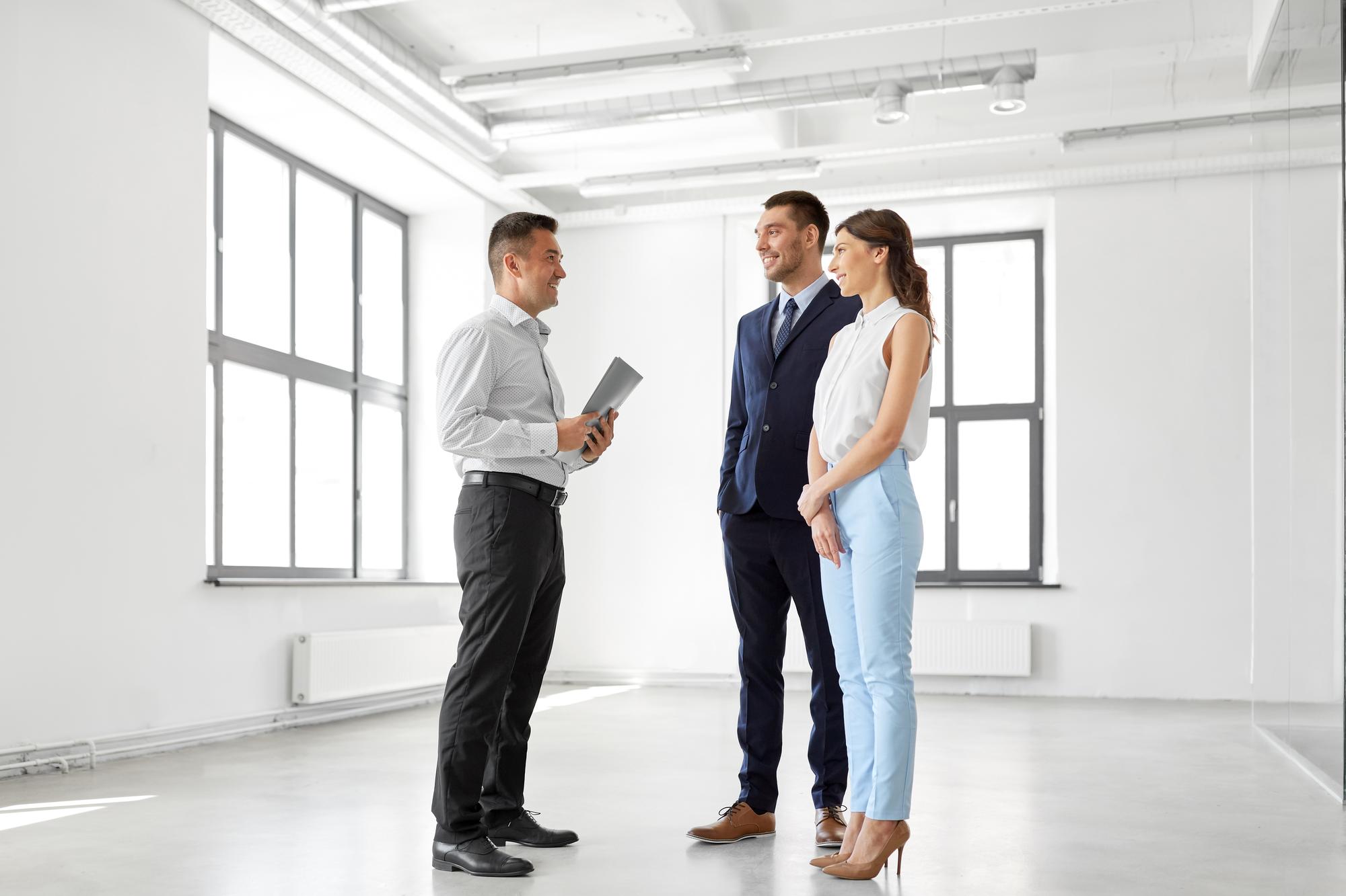 Agent imobiliare discutand cu proprietar in interiorul unui apartament modern
